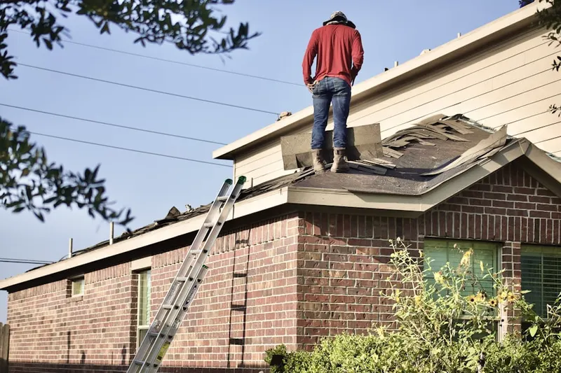 Professional roofer working on a residential roof in Oaks of Shenandoah